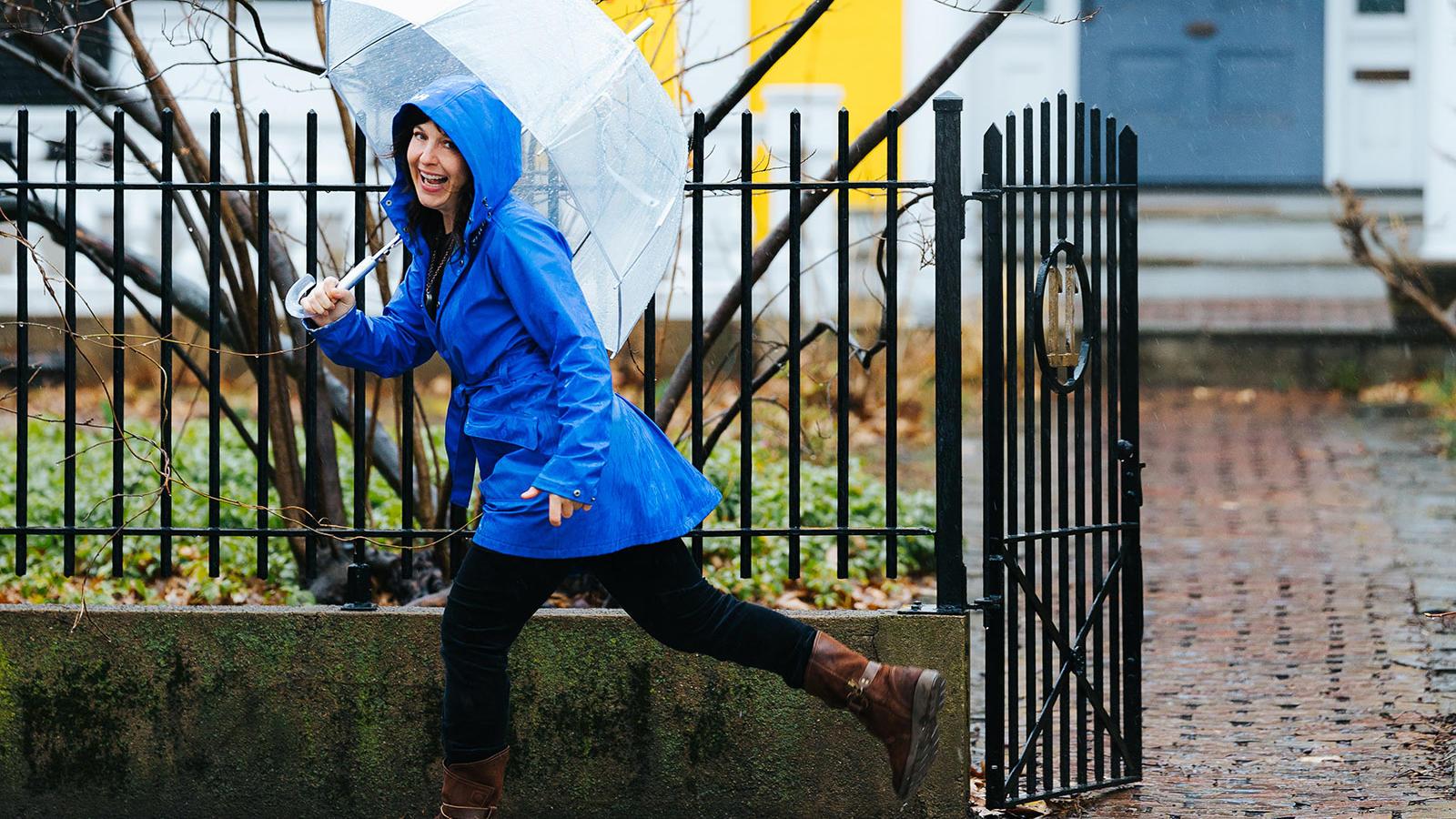 Sarah B. 米勒打着伞在雨中跳跃